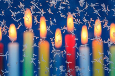 Ice flowers on glass pane in candlelight