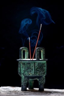 Incense burner with burning incense sticks