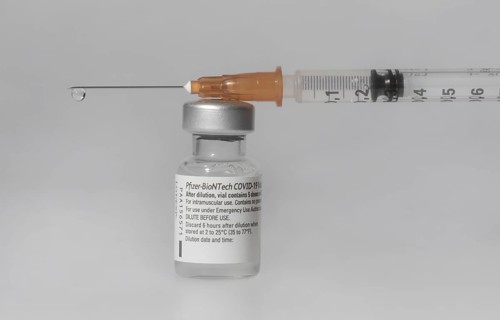 Vaccine vial against Covid 19 and syringe with drops