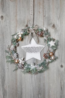 Christmas wreath on wooden wall with star