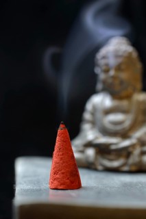 Burning incense cone with Buddha