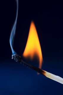 Burning match forms blue smoke