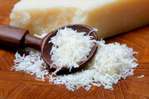 Grated Parmesan cheese and piece of Parmesan cheese