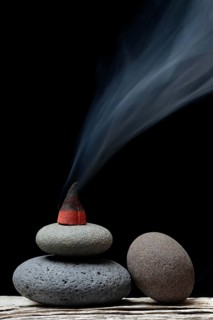 Burning incense cone on stones