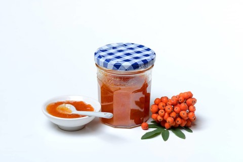 Glass of rowanberry and apple jam with n