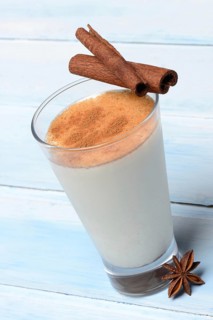 Cinnamon milk in glass with cinnamon sticks and star anise