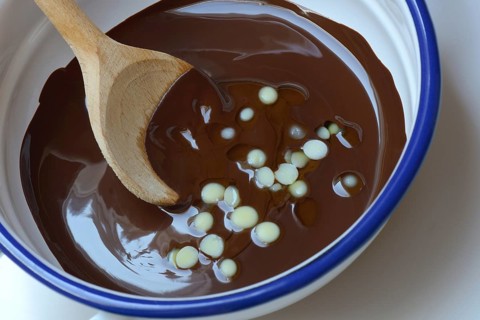 Liquid chocolate coating and melting cocoa butter with spoon