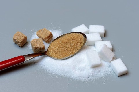 Spoon with cane sugar and white sugar