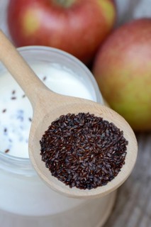 Psyllium plantain in cooking spoon on yoghurt glass and apples