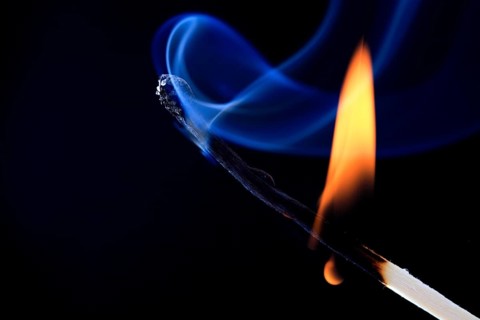 Burning match forms blue smoke