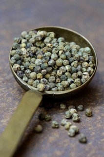 Green malabar pepper in brass ladle
