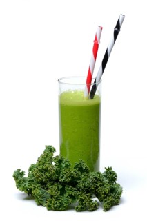 Kale smoothie in glass with drinking straw