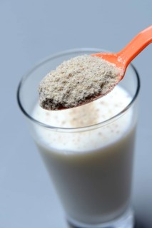 Tigernut flour in spoon and glass of milk