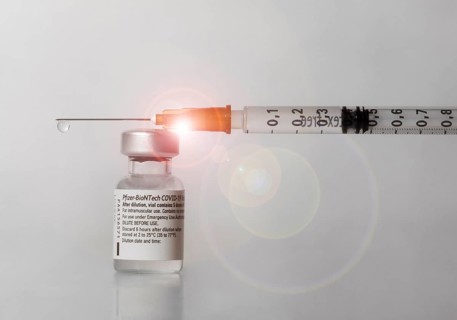 Vaccine vial against Covid 19 and syringe with drops