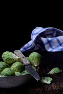 Brussels sprouts in bowl with kitchen knife