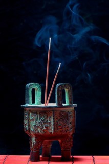 Incense burner with burning incense sticks