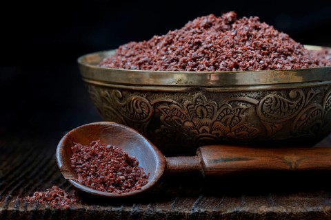Sumac powder in bowl and spoon