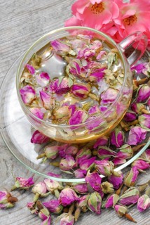 Rose tea in cup and rose buds