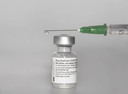 Vaccine vial against Covid 19 and syringe with drops