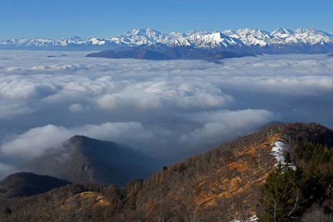 Snowy mountain range with Monte Rosa massif rising above sea of clouds