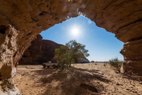 Off-road vehicle under rock arch