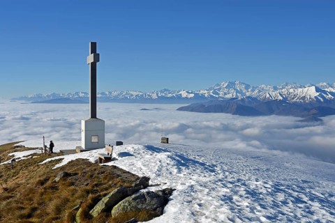 Summit cross of Monte Lema and sea of clouds over Lake Maggiore
