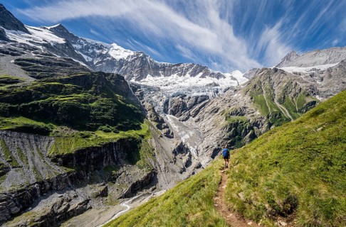 Hiker in the mountains on hiking trail to Grindelwald