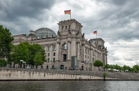 Reichstag building with waving German flag on the Spree