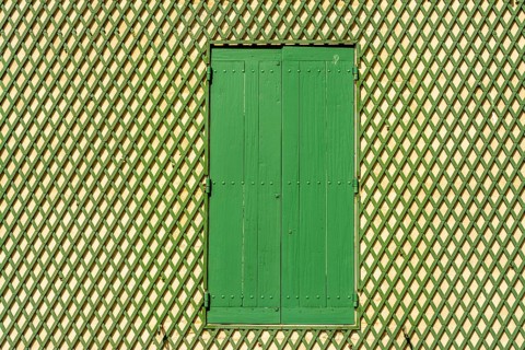 Green window on a wooden lattice wall