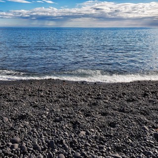 Black stones rounded by the sea