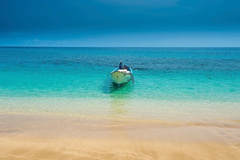 Little motorboat in the turquoise waters of Banana beach