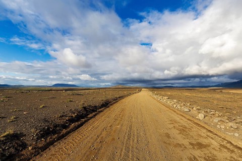 Lonely gravel road through volcanic landscape