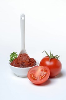Tomato paste with spoon in bowl