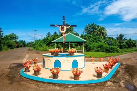 Christian statue at a road bend