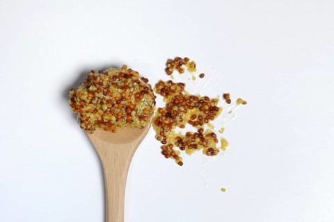 Grainy Dijon mustard on wooden spoon