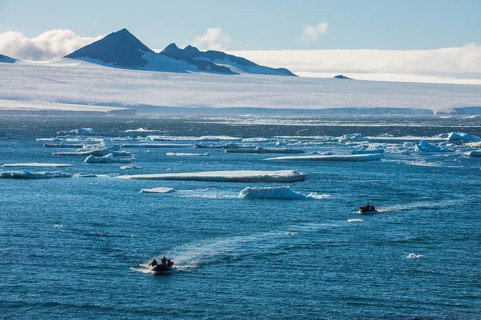 Zodiac with tourists cruising through the icebergs
