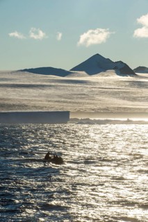 Backlight of a Zodiac with tourists cruising through the icebergs
