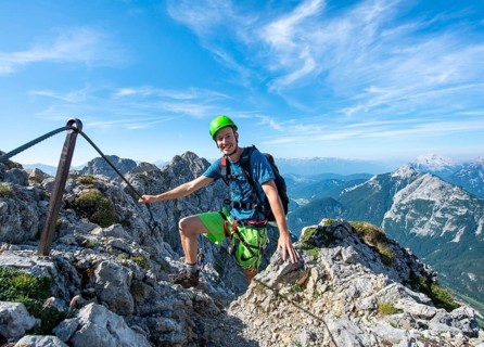 Mountaineer climbs a secured via ferrata