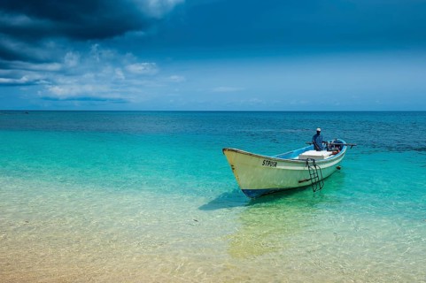 Little motorboat in the turquoise waters of Banana beach