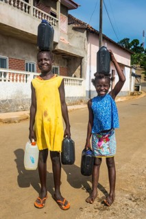 Friendly girls carrying a water canister