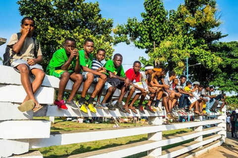 Boys on a wall watching the Carneval parade in the town of Sao Tome