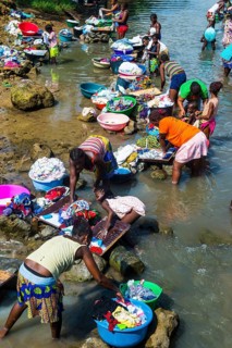 Women washing clothes in a river bed
