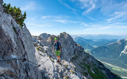 Mountaineer climbs on a secured fixed rope route