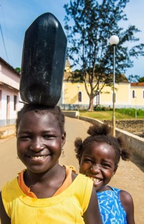 Friendly girls carrying a water canister