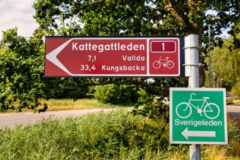 Signpost with pictogram bicycle for Swedish cycling routes Kattegattleden and Sverigeleden
