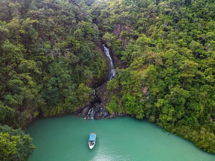 Aerial of a waterfall dropping right in the ocean on Dome island