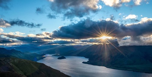 Last rays of sun shining through cloudy sky