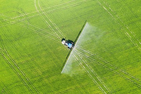 Tractor spraying fungicide onto the rice fields
