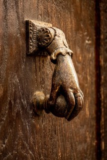 Knocker shaped like a hand on a wooden door