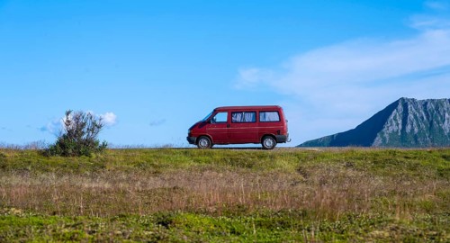 Red VW bus stands in the landscape